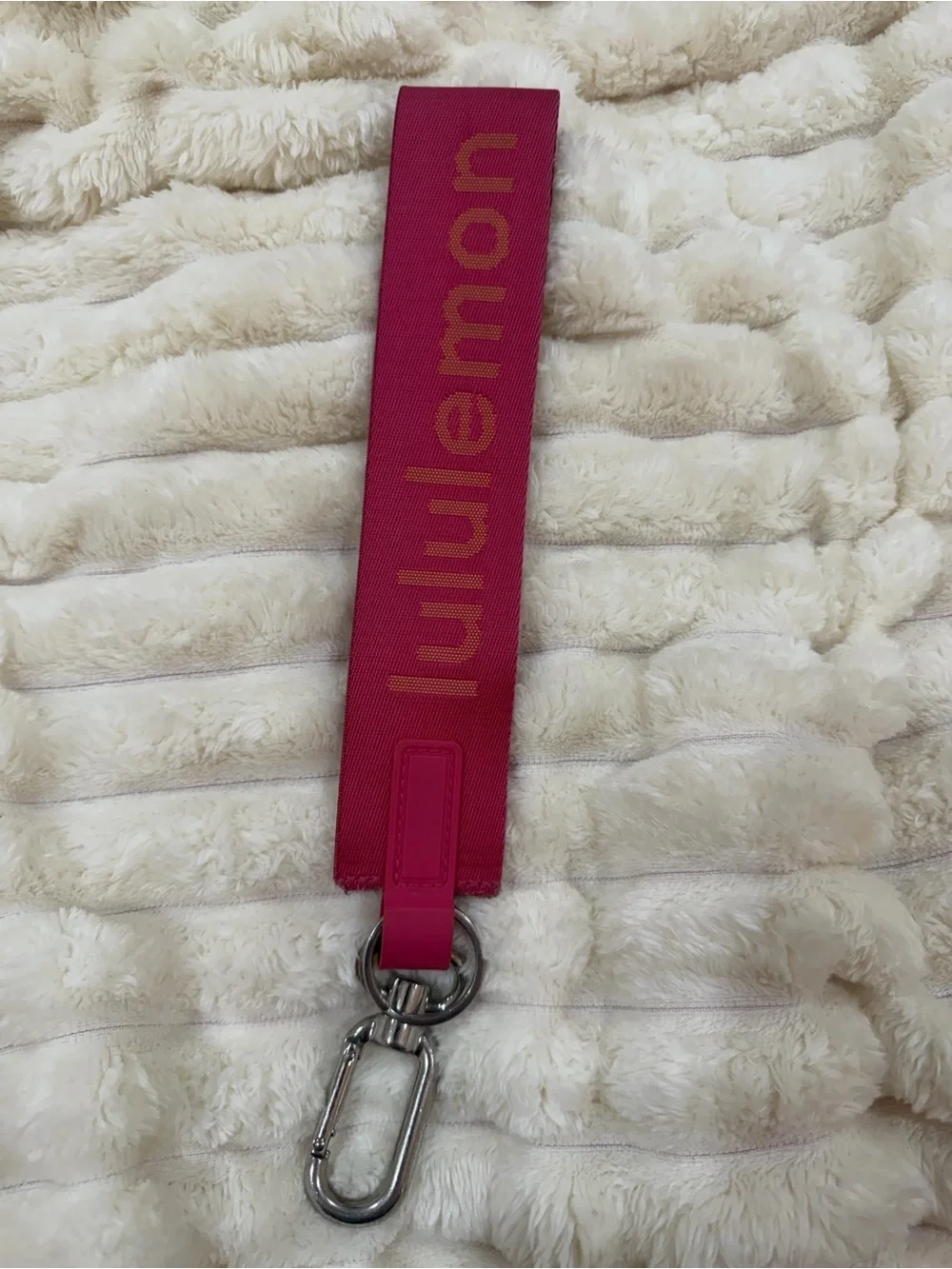 lululemon pink logo wristlet strap with orange lettering